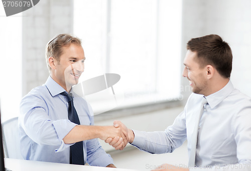 Image of businessmen shaking hands in office