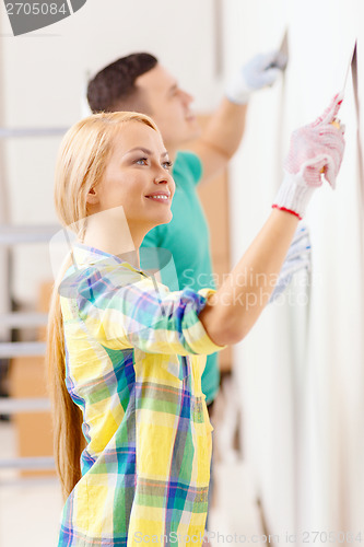 Image of smiling couple doing renovations at home