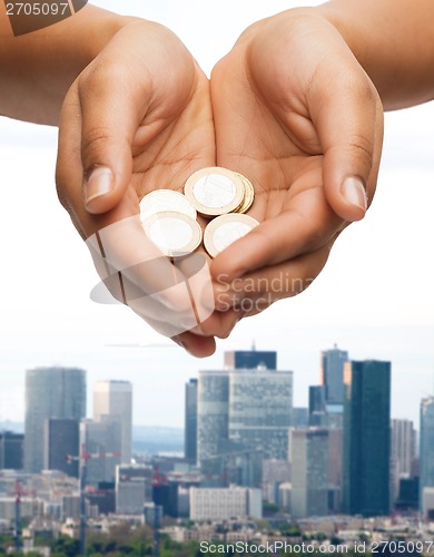 Image of womans cupped hands showing euro coins