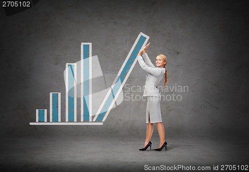 Image of young smiling businesswoman pushing up chart bar