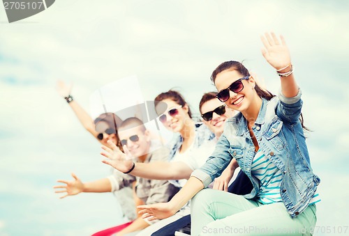 Image of group of teenagers waving hands