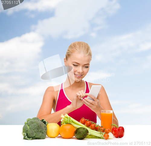 Image of woman with vegetables pointing at smartphone