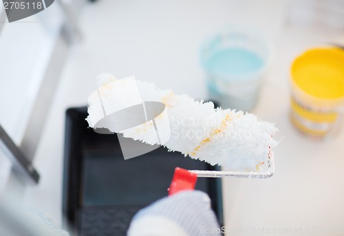 Image of close up of male in gloves holding painting roller