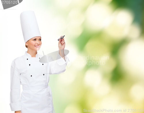 Image of smiling female chef writing something on air