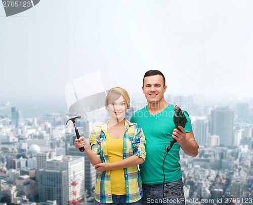 Image of smiling couple with hammer and drill