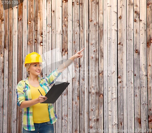 Image of smiling woman in helmet with clipboard