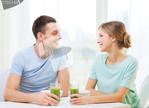 Image of smiling couple having breakfast at home