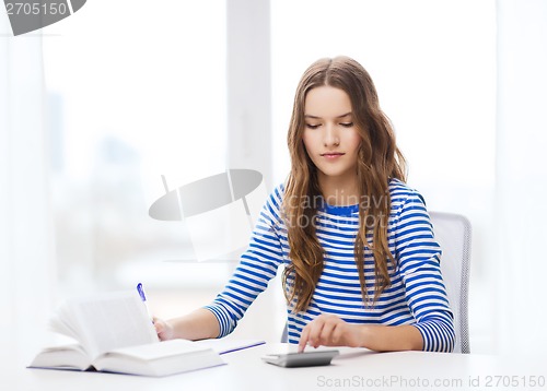 Image of student girl with book, calculator and notebook