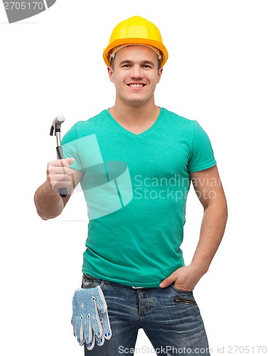 Image of smiling manual worker in helmet with hammer