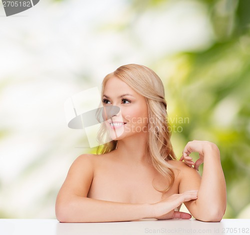 Image of woman touching her shoulder skin