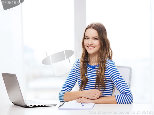 Image of smiling teenage girl laptop computer and notebook