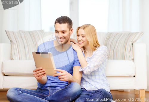Image of smiling happy couple with tablet pc at home
