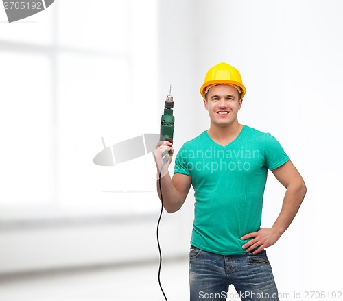Image of smiling manual worker in helmet with drill machine