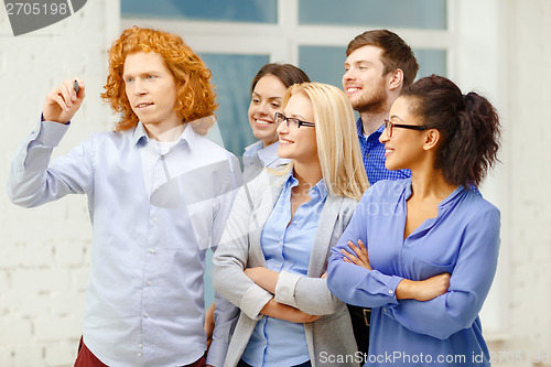 Image of smiling creative team writing on virtual screen