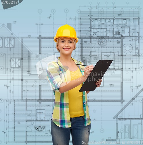 Image of smiling woman in helmet with clipboard