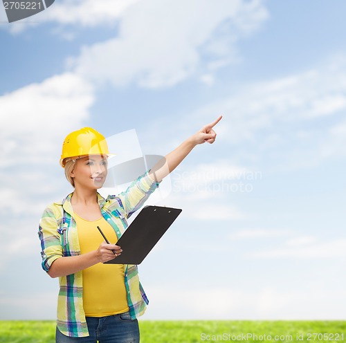 Image of smiling woman in helmet with clipboard