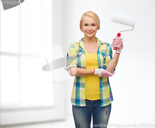 Image of smiling woman in gloves with paint roller