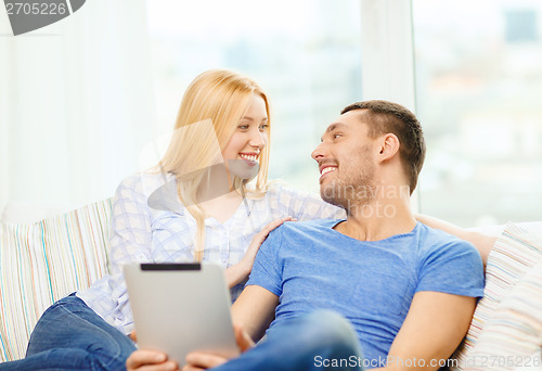 Image of smiling happy couple with tablet pc at home