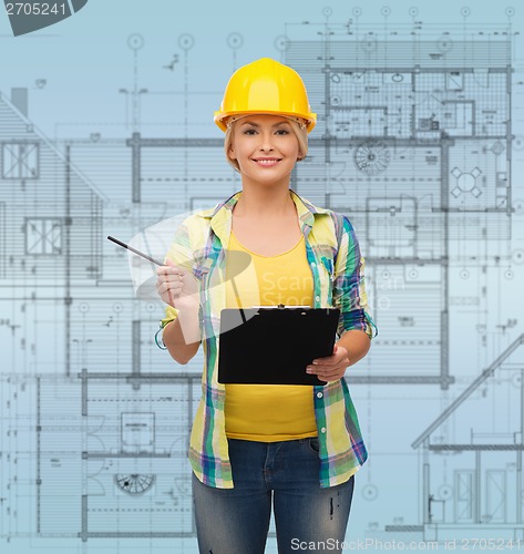 Image of smiling woman in helmet with clipboard