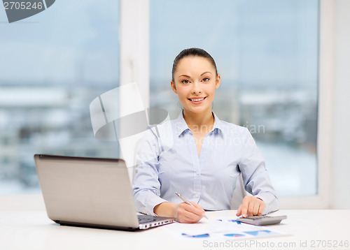 Image of businesswoman working with documents in office