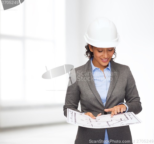 Image of businesswoman in white helmet with blueprint