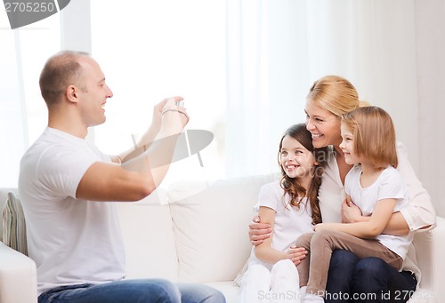 Image of father taking picture of mother and daughters