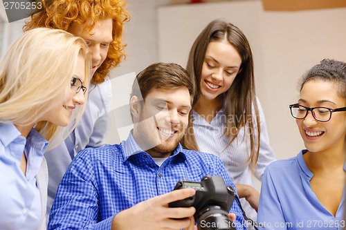 Image of smiling team with photocamera in office