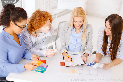 Image of team with color samples and blueprint at office