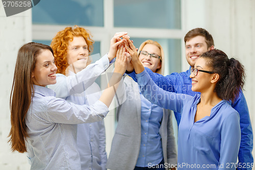 Image of creative team doing high five gesture in office