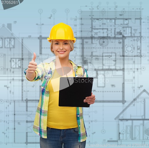 Image of smiling woman in helmet with clipboard