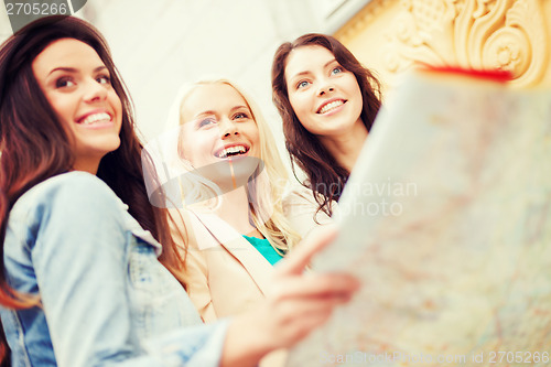 Image of beautiful girls looking into tourist map in city