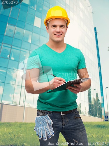 Image of smiling man in helmet with clipboard