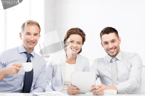 Image of business team having fun with tablet pc in office