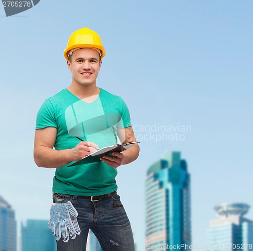 Image of smiling man in helmet with clipboard