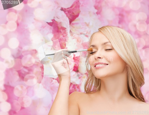 Image of beautiful woman with closed eyes and makeup brush