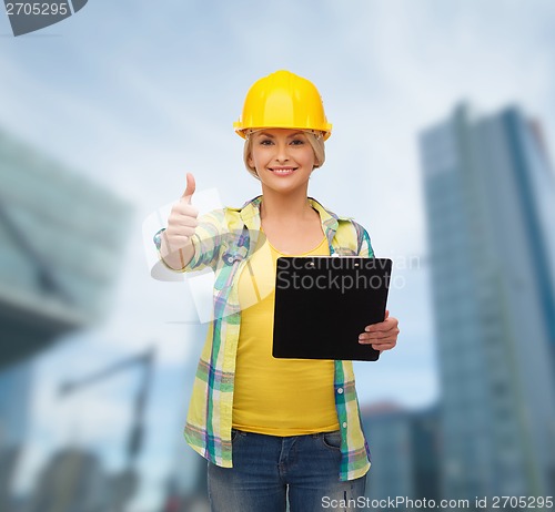 Image of smiling woman in helmet with clipboard