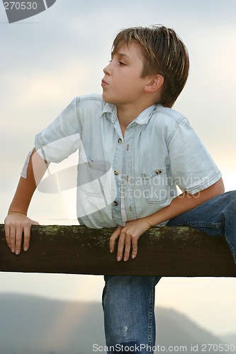Image of Boy climbing on a fence