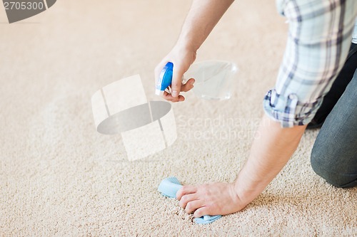 Image of close up of male cleaning stain on carpet