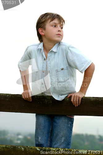 Image of Child leaning on a fence