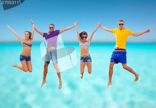 Image of group of friends or couples jumping on the beach