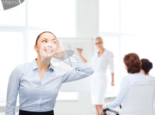 Image of smiling businesswoman listening gossig