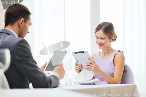 Image of couple with menus on tablet pc at restaurant