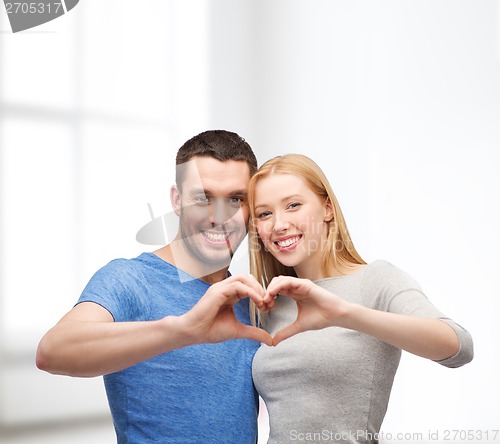 Image of smiling couple showing heart with hands