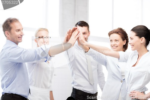 Image of business team celebrating victory in office