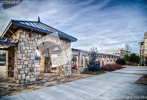 Image of cultured stone terrace trellis details near park in a city 