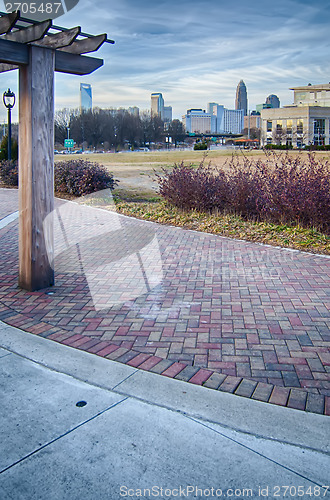 Image of cultured stone terrace trellis details near park in a city 