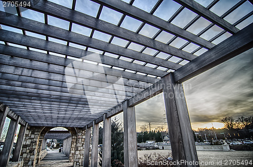 Image of cultured stone terrace trellis details near park in a city 