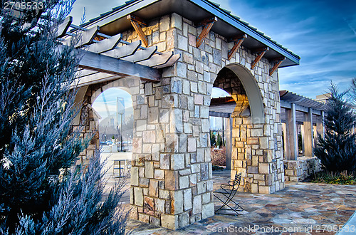 Image of cultured stone terrace trellis details near park in a city 