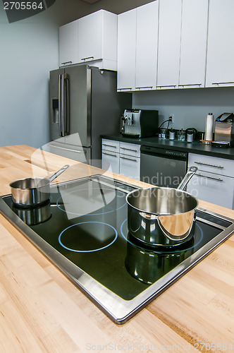 Image of kitchen butcher table island with stove top and pans