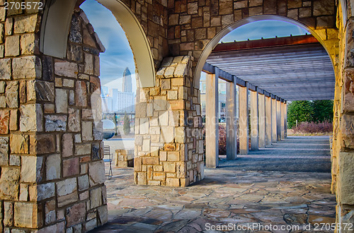 Image of cultured stone terrace trellis details near park in a city 